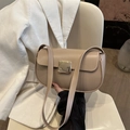 Elegant beige leather saddle bag with large gold buckle on white corduroy suit - Khaki