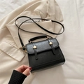 Retro black leather crossbody bag with golden buckle details on a blazer - Black