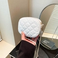 White quilted mini crossbody bag with gold chain strap held by a hand for size scale - White
