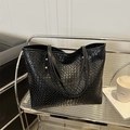 Minimalistische schwarze gewebte Leder-Tote-Bag mit Goldnieten auf silbernem Wagen - Schwarz