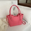 Elegant bright pink trapezoid tote bag with gold hardware shown on a soft silk background - Pink