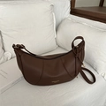Retro dark brown pebbled leather crescent handbag with elegant gold lettering on white bedding - Brown