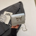 Minimalist silver chain crossbody bag featuring a metal bow and chic metallic finish - Silver