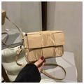 Detail of beige woven cassette bag with wide padding texture and matte hardware finish - Khaki