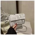 Close-up of silver woven cassette crossbody bag with metallic pleated texture and strap - Silver