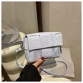 Close-up of light blue woven leather bag with marble texture and silver buckle - Blue