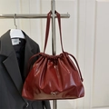 Minimalist deep red glossy bucket bag with drawstring and silver bow accent - Red