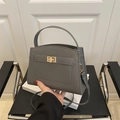 Graue kleine quadratische Handtasche aus Leder mit goldenem Drehverschluss und Gurt - Grau