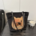 Sac fourre-tout noir avec patch chat et broderie posé sur une table en bois - Noir