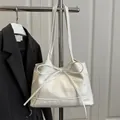 Sac à bandoulière blanc minimaliste avec nœud décoratif et texture en cuir PU sur rack - Blanc