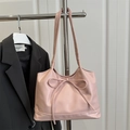 Sac fourre-tout rose chic avec grand nœud suspendu à un cintre sur fond de costume sombre - Rose