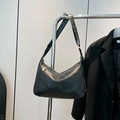 Minimalist black faux leather pillow shoulder bag with adjustable strap and fashion label - Black