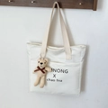 Minimalistische beige Canvas-Einkaufstasche mit Außentasche und Strickbär-Anhänger - Mit Anhänger / Gebrochenes Weiß