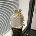 White snake texture bucket bag featuring elegant pearl handle and gold chain strap - White