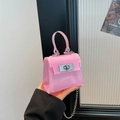 Pink mini jelly handbag with silver twist lock and chain strap in a lifestyle setting - Pink