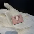 Portacarte in pelle intrecciata rosa con chiusura a scatto su sfondo di seta - Rosa