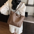 Grande borsa tote marrone minimalista con trama a grana e logo argento portata a spalla - Marrone