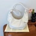 Borsa a mezzaluna bianca plissettata con tracolla a nodo su divano in pelle - Bianco Sporco