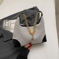Détail du sac bandoulière en toile tissée avec garniture en cuir noir et pendentif cerf doré - Kaki et Noir