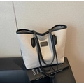 Dettaglio della borsa tote in tela beige con finiture e manici in pelle nera - Nero