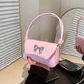 Chic pink handbag with silver bow detail and knotted handle shown in a stylish interior - Pink