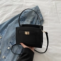 Bolso bandolera negro minimalista con cierre de giro dorado y acabado texturizado - Negro