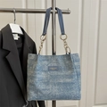 Bolso tote de mezclilla azul con tachuelas metálicas y cadena dorada al hombro - Azul claro