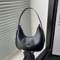 Minimalist black crescent hobo bag featuring a silver metal bow accent and thin shoulder strap - Black