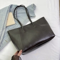 Deep brown large tote bag with glossy leather texture and double handles in a casual setup - Brown