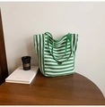 Détail d'un sac cabas en toile à rayures vertes et blanches avec logo ovale sur table en bois - Vert Double Face