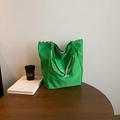 Emerald green nylon tote bag with artistic lettering and checkered lining on a wooden table - Green Side B (Letter Print)