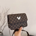 Brown vintage crossbody bag with butterfly decor and monogram print on leather surface - Brown