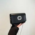 Classic black square crossbody bag with a sparkling rhinestone buckle and silver chain - Black