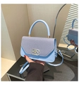 Macro shot of light blue denim and leather bag featuring a gold metal buckle closure - Blue