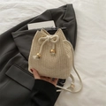 Schicke cremefarbene Stroh-Beuteltasche mit Kordelzug und goldenen Metalldetails - Gebrochenes Weiß