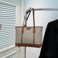 Beige monogram shopper met bruine lederen bies en slanke handvatten in showroom - Khaki