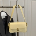 Minimalistische cremegelbe Leder-Achseltasche mit Goldschloss am Metallkleiderbügel - Gelb