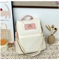 Detail of waterproof nylon backpack with rabbit patch and red-green striped strap - White