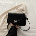 Sleek black leather crossbody bag with a unique silver heart buckle and slim shoulder strap - Black