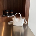 Chic white lychee grain bucket bag with dual handles and gold hardware details - White