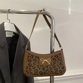 Leopard print underarm bag with brown leather trim and a golden bow accent piece - Brown