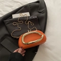 Modern orange glossy pillow bag with bold gold metal handle and slim chain strap - Orange