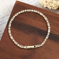 Elegante vergulde tennisarmband met baguette en ronde zirkoniasteentjes op hout. - Goud