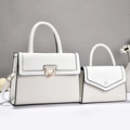 Detail der weißen Handtasche mit gewebten Texturen und goldenen Metallbeschlägen im Set - Weiß