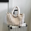 Borsa tote in peluche bianco crema con strisce verticali e manici intrecciati su una valigia - Bianco Sporco