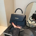 Elegante borsa a tracolla in pelle nera opaca con manico intrecciato e barra metallica - Nero