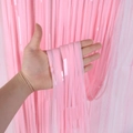 Primo piano della tenda di ghirlande rosa che mostra la consistenza lucida e le frange fitte - 1x2m / Rosa Macaron