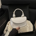 White faux leather crossbody bag with knot handle and gold hardware on silk background - White