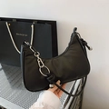 Chic black crescent underarm bag with silver metallic charm and minimalist nylon texture - Black