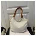 Detalle del bolso tote de lona blanca con correas marrones en un estilo moderno - Blanco y Marrón